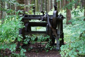photo d'une ancienne machine délabrée au milieu d'une forêt
